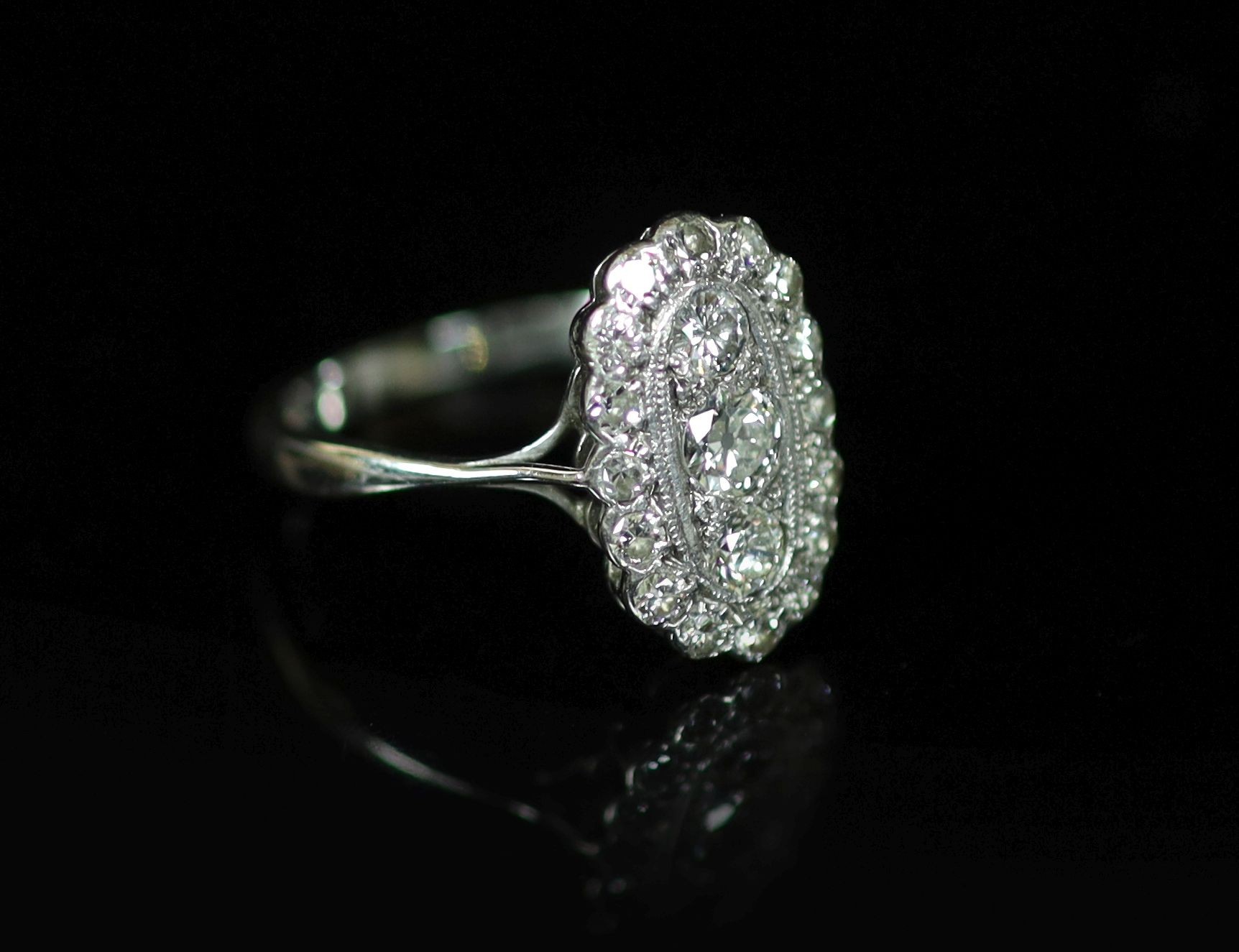 A 1940's 18ct white gold and diamond set oval cluster ring